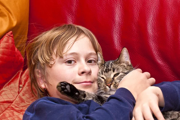 Молодий хлопчик обіймає свого кота — стокове фото