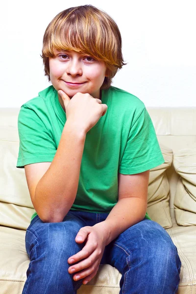微笑的男孩坐在一张沙发上 — 图库照片