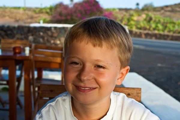 Chłopiec siedzi w restaurację na świeżym powietrzu — Zdjęcie stockowe