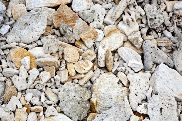 Belle pietre strutturate in spiaggia in modo armonico dà un — Foto Stock