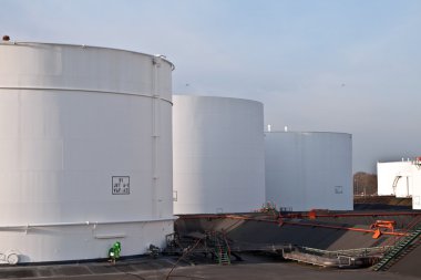 White tanks in tank farm with blue sky clipart