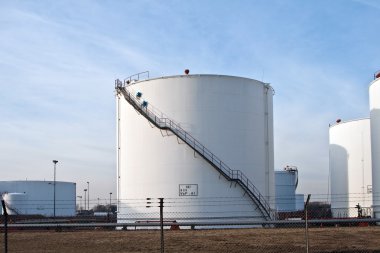 White tanks in tank farm with blue sky clipart