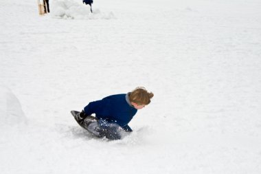 Çocuk kar, beyaz kışın tepeden aşağı sledging