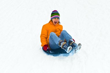 Boy lying in snow has fun clipart