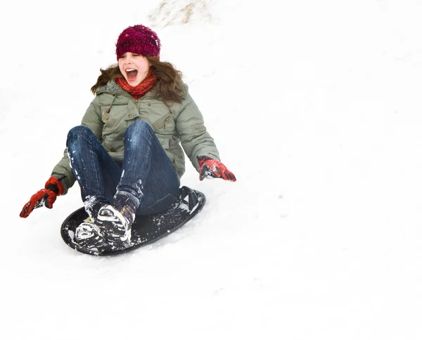 Menina trenó descendo a colina na neve no inverno — Fotografia de Stock