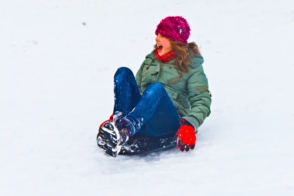 Menina trenó descendo a colina na neve no inverno — Fotografia de Stock