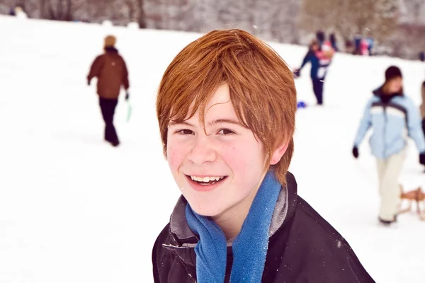 Хлопчик з рудим волоссям насолоджується снігом — стокове фото