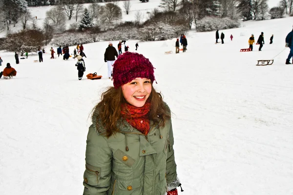 Meisje op een besneeuwde heuvel in de winter — Stockfoto