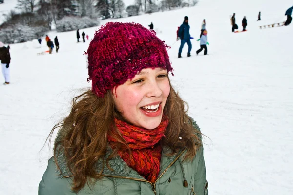 Meisje op een besneeuwde heuvel in de winter — Stockfoto