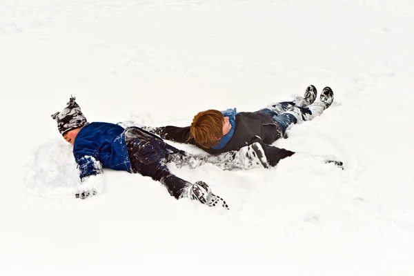Brothers lying in snow — Stock Photo, Image