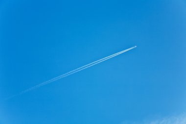 Blue sky with condension trail of an aircraft clipart