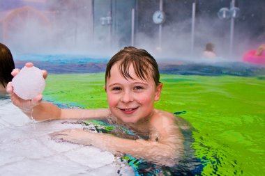 Children having fun in the outdoor thermal pool clipart