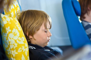 Young passenger sleeping in the aircraft clipart