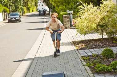 Çocuk bir scooter paveway sürmek.