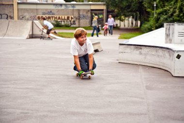 Cute boy scooting with his scooter clipart