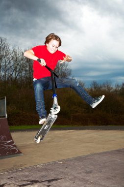 Boy going airborne with a scooter clipart