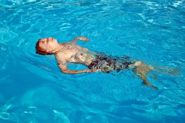 çocuk havuzunda yüzüyor