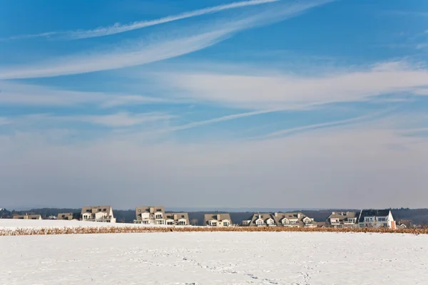Landschap met huisvesting gebied in sneeuw en blauwe hemel — Stockfoto