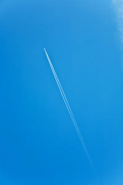 Céu azul com rastro de condensão de uma aeronave — Fotografia de Stock