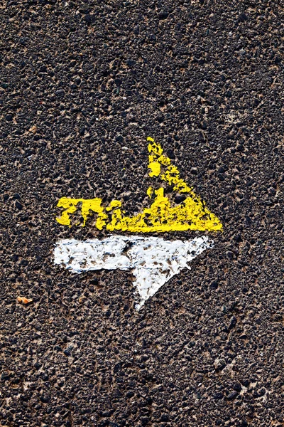 Arrow in yellow and white on a paveway for orientation — Stock Photo, Image