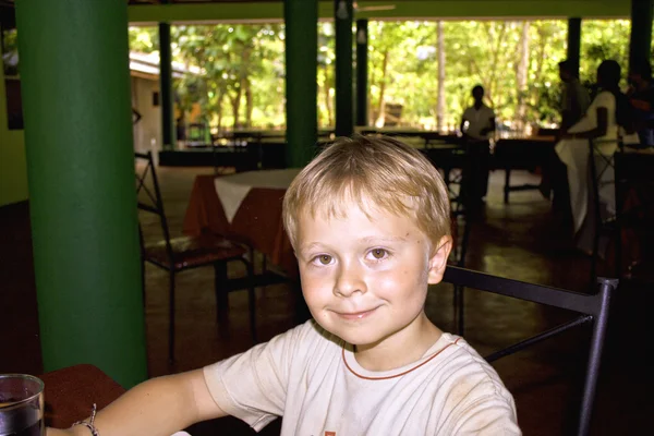 Мальчик, сидящий на территории отеля, наслаждается отдыхом — стоковое фото