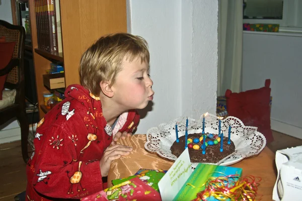 Menino sopra suas velas de aniversário — Fotografia de Stock