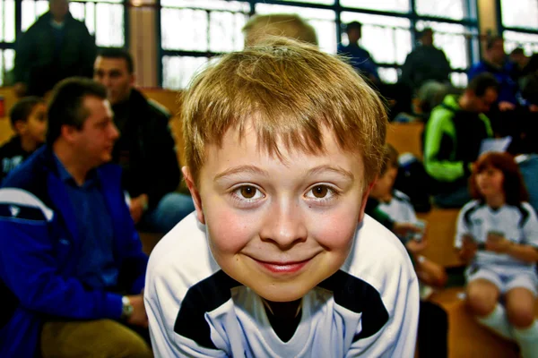 Niño en la arena de fútbol sonríe —  Fotos de Stock