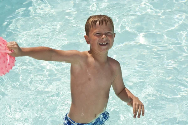 Jovem rapaz se diverte na piscina — Fotografia de Stock