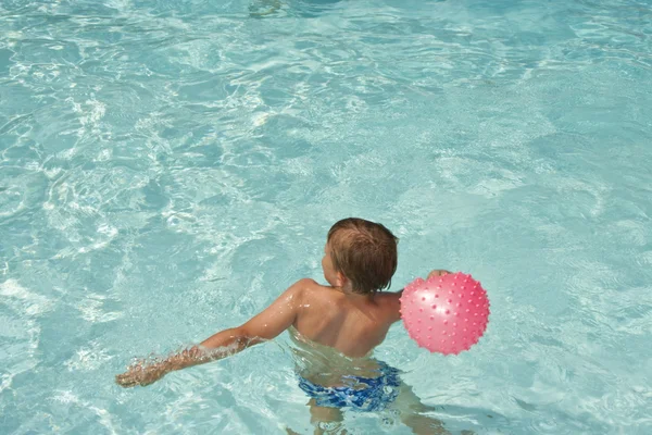 Jovem rapaz se diverte na piscina — Fotografia de Stock