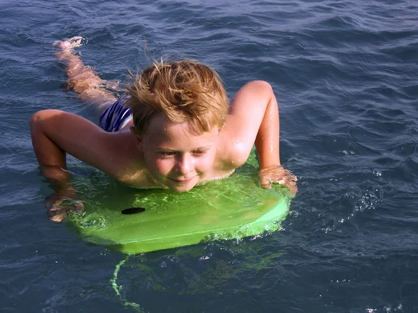어린 소년이 바다에서 서핑 — 스톡 사진