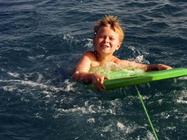 Niño está surfeando en el océano —  Fotos de Stock