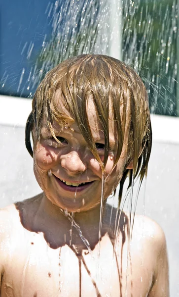 Kind hat erfrischende Dusche — Stockfoto