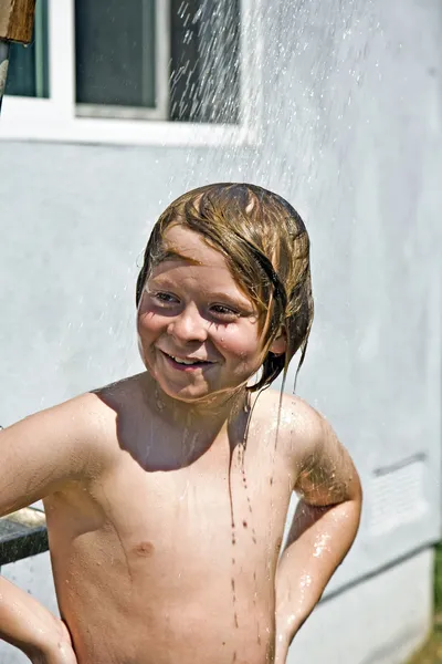 Ребенок имеет освежающий душ — стоковое фото