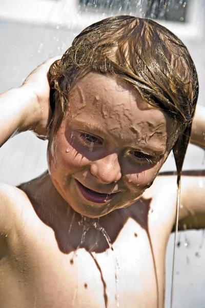 Niño tiene una ducha refrescante —  Fotos de Stock