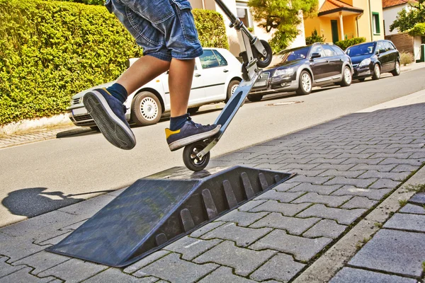 Menino monta uma scooter no paveway — Fotografia de Stock