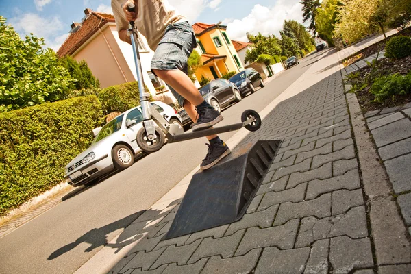 stock image Boy riding a scooter going airborne