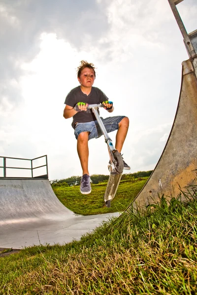 Boy rides scooter in the halfpipe — Stock Photo, Image