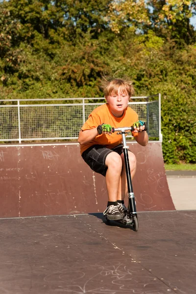 소년은 스케이트 공원에서 스쿠터를 타고 — 스톡 사진