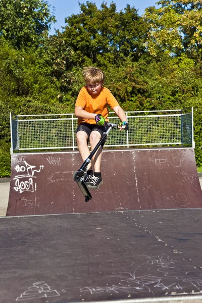 Chlapec jezdí na skútru na skate park — Stock fotografie