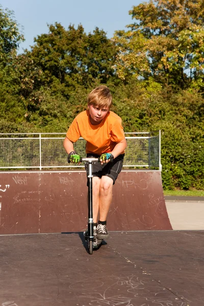 Chlapec jezdí na skútru na skate park — Stock fotografie