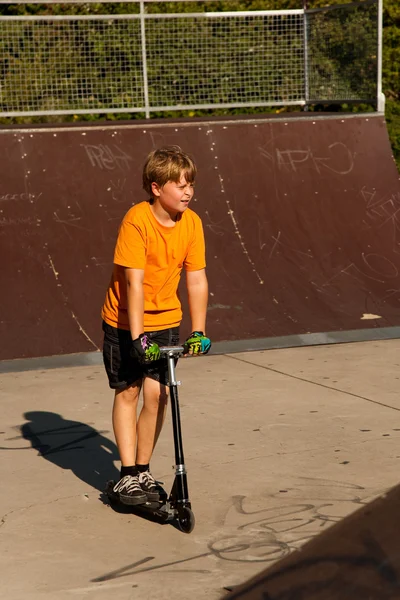 Junge fährt Roller im Skatepark — Stockfoto