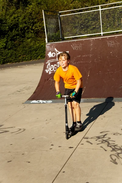 男孩骑踏板车在滑板公园 — 图库照片