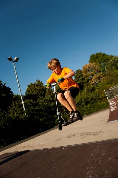Junge fährt Roller im Skatepark — Stockfoto