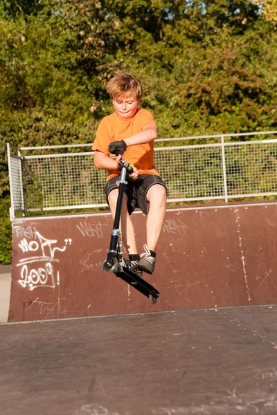 Menino monta scooter no parque de skate — Fotografia de Stock