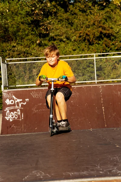 Хлопчик катається на скутері в скейт-парку — стокове фото