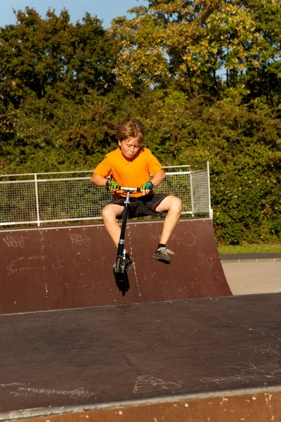 소년은 스케이트 공원에서 스쿠터를 타고 — 스톡 사진