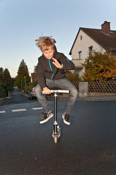 Carino ragazzo scooting con la sua scooter — Foto Stock
