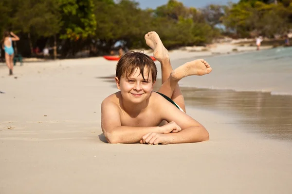 快乐的孩子躺在沙滩上 — 图库照片