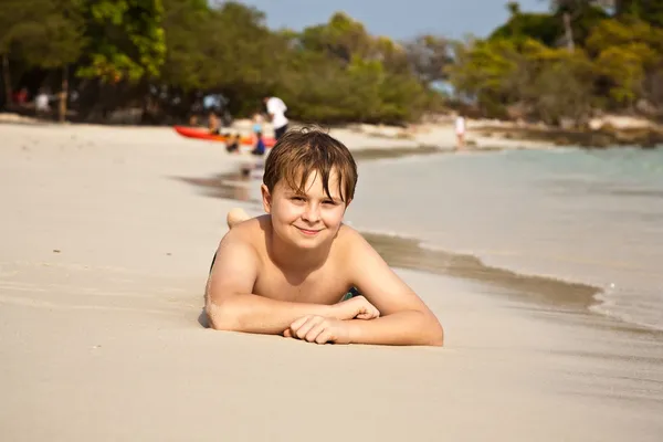 ビーチで横になっている幸せな少年 — ストック写真