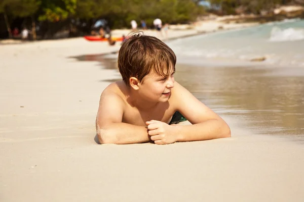 Joyeux garçon allongé sur la plage — Photo
